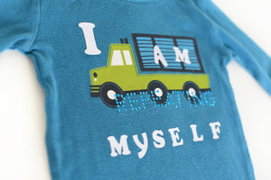 A blue child's shirt with truck decal and the words, 